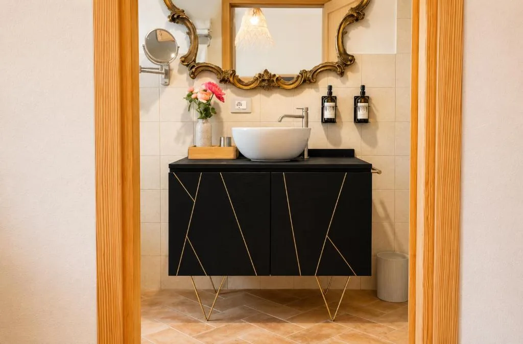 Camera 3 — il bagno con specchiera barocca e mobile nero